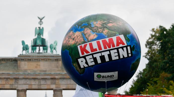 ein Ballon mit der Aufschrift „Klima retten“ schwebt vor dem Brandenburger Tor /Quelle: AFP/Getty Images/J. MacDougall
