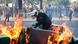 A French policeman tries to separate burning rubbish bins during protests in Paris A French policeman tries to separate burning rubbish bins during protests in Paris