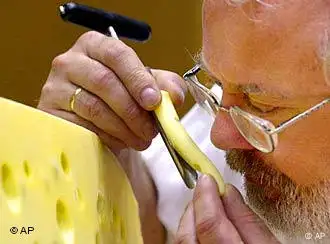 Ein Mann riecht an einem Stück Allgäuer Emmentaler Käse