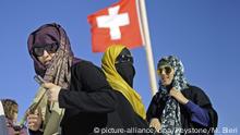 ARCHIV - 19.07.2010, Schweiz, Jungfraujoch: ILLUSTRATION - Touristinnen mit Kopftuch vor einer Schweizer Nationalflagge auf dem Jungfraujoch im Berner Oberland. In der Schweiz führt St. Gallen als zweiter Kanton nach dem Tessin ein Verhüllungsverbot ein. Im Volksmund ist von Burka-Verbot die Rede, weil damit die Verschleierung muslimischer Frauen verhindert werden soll. 66,65 Prozent waren dafür, wie die Regierung am Sonntag (23.09.2018) mitteilte. Der Kanton liegt südlich des Bodensees und hat rund 500 000 Einwohner. Foto: Marcel Bieri/KEYSTONE/dpa +++ dpa-Bildfunk +++ |