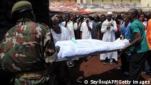 Soldiers unload bodies of victims shot dead by Guinea junta forces at the September 28, 2009 demonstration in front of the Conakry great mosque on October 2, 2009. Several dozen bodies of victims shot dead by Guinea junta forces at a demonstration were put on display today at a new rally by thousands of people in the capital. The new show of public anger came after military ruler Captain Moussa Dadis Camara proposed talks with the opposition. Several thousand people gathered in front of the main mosque in Conakry after a religious official made an appeal for families to come and identify the dead from Monday's shootings in a stadium where tens of thousands of opposition supporters had gathered. AFP PHOTO / SEYLLOU = GRAPHIC CONTENT (Photo credit should read SEYLLOU/AFP/Getty Images)