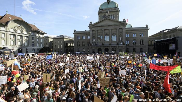 People take part in a climate change protest outside of Swiss Parliament in Bern, Switzerland