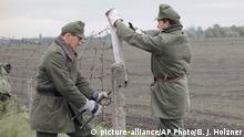 Hungarian border guards cut a hole into the Iron Curtain, May 2, 1989, opening its border with Austria and the west near Hegyeshalom, some 50 kilometers east of Vienna. Hungary began dismantling its border fortifications. (AP Photo/Bernhard J. Holzner) |