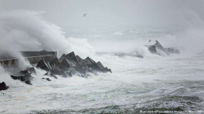 Waves crashing against coastal defenses 