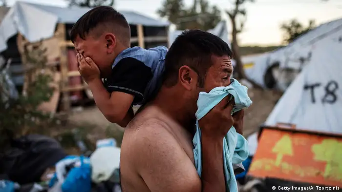 A man and boy crying after a clashes and a fire at the Moria refugee camp
