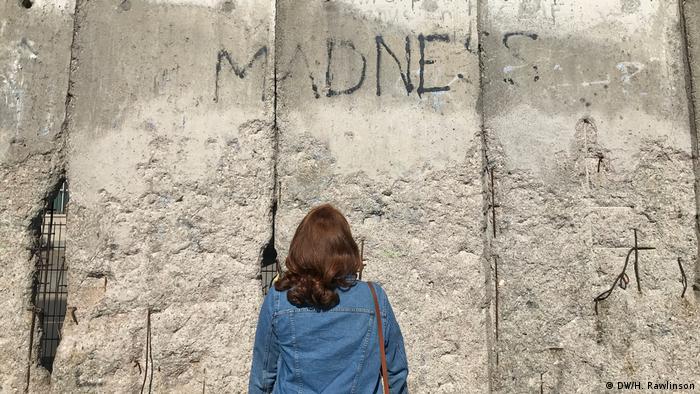 Туристка осматривает фрагменты Берлинской стены