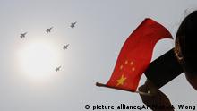A woman holding a Chinese national flag films Chinese military planes fly in formation past the sun during a parade to commemorate the 70th anniversary of the founding of Communist China in Beijing, Tuesday, Oct. 1, 2019. China's Communist Party is celebrating its 70th anniversary in power with a parade showcasing its economic development and newest weapons. The event marks the anniversary of the Oct. 1, 1949, announcement of the founding of the People's Republic of China by then-leader Mao Zedong. (AP Photo/Andy Wong) |
