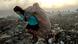 A girl carrying a sack of trash on a sprawling dump site A girl carrying a sack of trash on a sprawling dump site