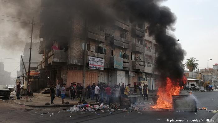 Protest in Bagdad show smoke rising from a dumpster that is on fire as part of anti-government protests (picture-alliance/dpa/H. Mizban)