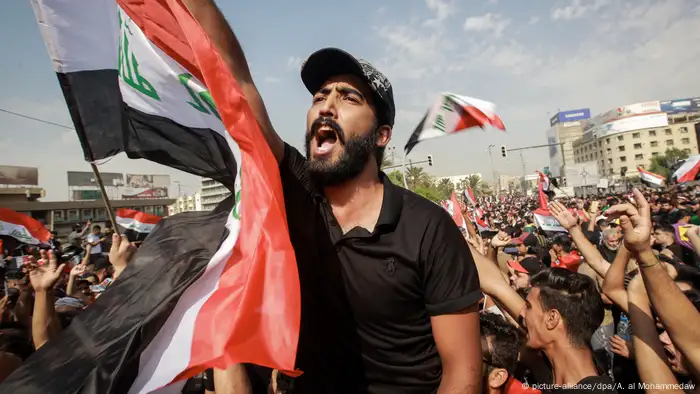 A man waves an Iraqi flag at anti-government protests in downtown Baghdad (picture-alliance/dpa/A. al Mohammedaw)