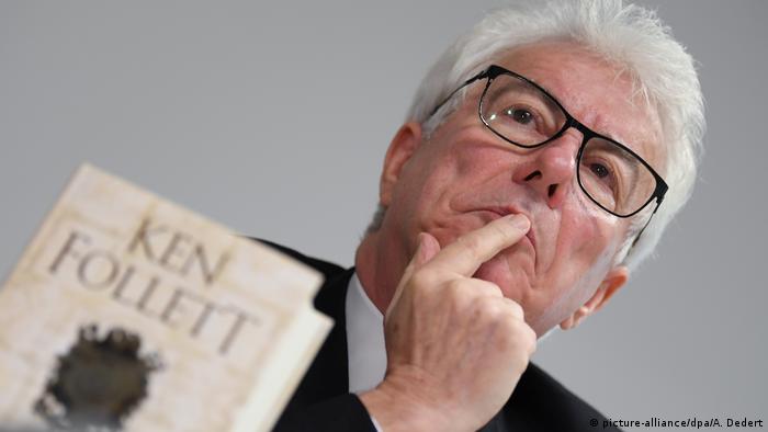 Ken Follett with a cover of one of his books in the foreground.