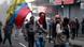 A protester in Ecuador holds an Ecuadorian flag and wears a bandanna covering her face A protester in Ecuador holds an Ecuadorian flag and wears a bandanna covering her face