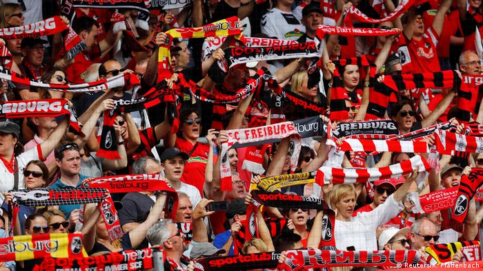 Freiburg-Fans mit Fan-Schals vor einem Spiel im Stadion