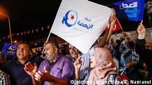 06.10.2019, Tunesien, Tunis: Anhänger der islamistischen Ennahda-Partei nehmen an einer Feier vor dem Parteizentrum teil. In Tunesien wird nach der Parlamentswahl eine schwierige Regierungsbildung erwartet. Zwei Parteien erklärten sich nach der Schließung der Wahllokale am Sonntagabend zum Sieger. Die moderat islamistische Ennahda bekam laut Nachwahlumfragen die meisten Stimmen. Foto: Khaled Nasraoui/dpa +++ dpa-Bildfunk +++