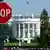 Красный знак с надписью "Стоп" на фоне Белого дома в Вашингтоне