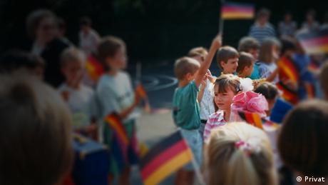 Children holding up German flags in blurry focus