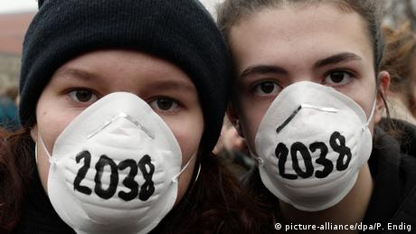 German environment protesters wear face masks with the date 2038 written on them 