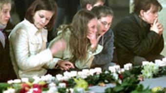 Unidentified people grief over the victims of a school shooting in the Cathedral of Erfurt, eastern Germany, Saturday, April 27, 2002, the day after a former student killed 16 people before he killed himself in the Gutenberg high school. (AP Photo/Michael Probst)