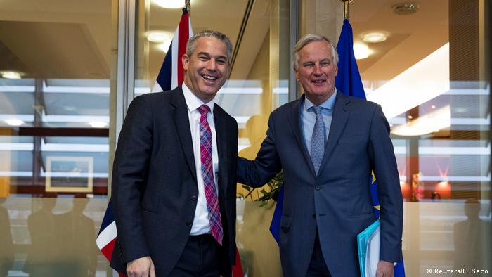 Brexit Secretary Stephen Barclay and EU Chief Negotiator Michel Barnier tap each other on the back.