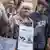 Com a frase "Fora, nazistas" pendurada no pescoço, Irmela Mensah-Schramm participa de manifestação contra o racismo em Berlim
