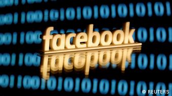 FILE PHOTO: Facebook logo is seen in front of displayed binary code in this illustration picture