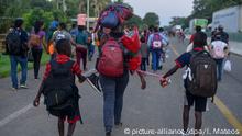 12.10.2019, Mexiko, Tapachula: Migranten mit Taschen voller Habseligkeiten gehen den Highway 200 entlang auf dem Weg nach Huixtla bei Tapachula, Chiapas. Die Migranten aus Afrika, Kuba, Haiti oder anderen mittelamerikanischen Ländern brechen am frühen Morgen zu Fuß von Tapachula bis zur Südgrenze der Vereinigten Staaten auf. Foto: Isabel Mateos/AP/dpa +++ dpa-Bildfunk +++