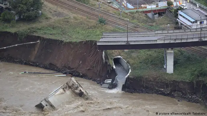 An aerial photo shows a bridge and road collapsed due to the Chikuma River overflowing