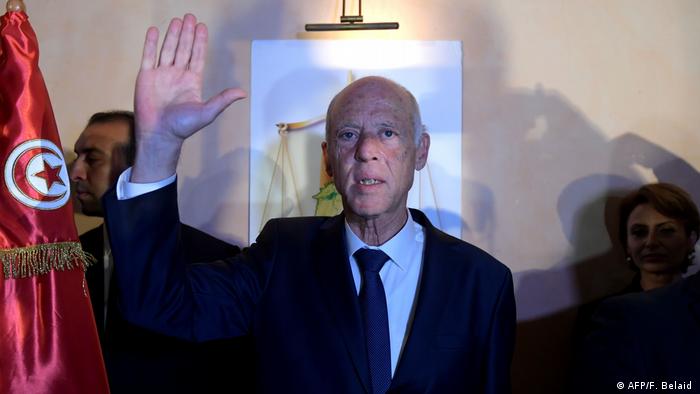 Kais Saied raises his hand while celebrating his electoral victory in 2019