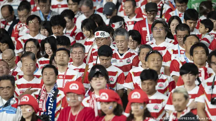 Japanese fans close their eyes at the moment of silence for the typhoon victims (picture-alliance/ZUMAPRESS/R. Reyes Marin)