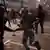 Demonstrators run away from Police officers outside El Prat airport in Barcelona