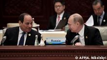 Russia's President Vladimir Putin (R) listens to Egypt's President Abdel Fattah al-Sisi (L) before a roundtable summit session on the final day of the Belt and Road Forum in Beijing on April 27, 2019. - Chinese President Xi Jinping urged dozens of world leaders on April 27 to reject protectionism and invited more countries to participate in his global infrastructure project after seeking to ease concerns surrounding the programme. (Photo by Aleksey Nikolskyi / Sputnik / AFP)