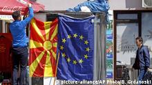 A street vendor fixes a North Macedonia flag next to an EU flag in a street in Skopje, North Macedonia, Friday, May 3, 2019. Voters in newly-renamed North Macedonia will choose the country's new president Sunday, in tightly-contested polls that could see the ethnic Albanian minority playing a major role. (AP Photo/Boris Grdanoski) |
