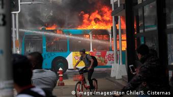 A bus on fire in a Chilean street