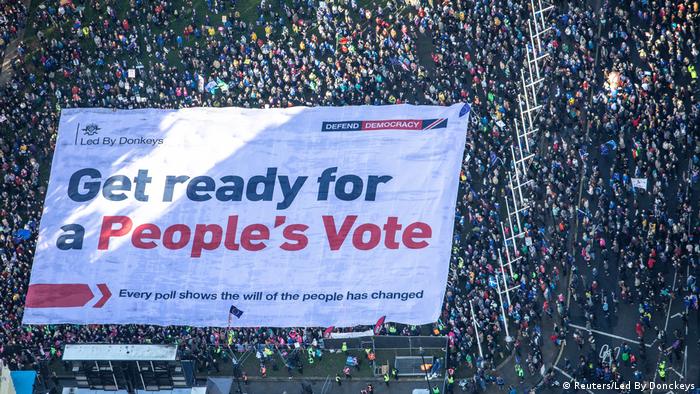 An aerial view shows Brexit accountability campaign group Led By Donkeys unfurling a large crowd banner, as a spoof of the government's advertising campaign