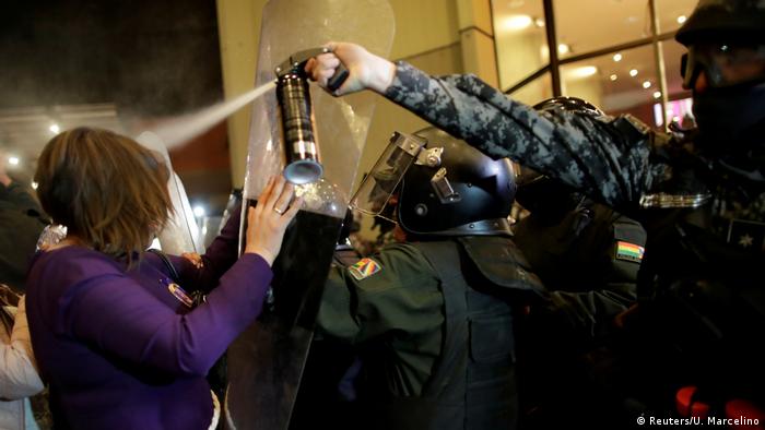 Un policía lanza gases lacrimógenos a una manifestante en La Paz. (21.10.2019).