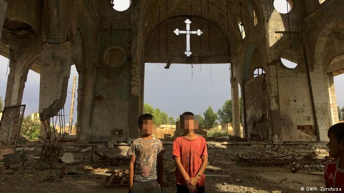 Two boys stand in a destroyed church