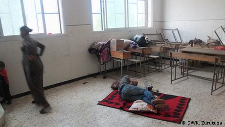 A man lying on a rug in an abandoned school