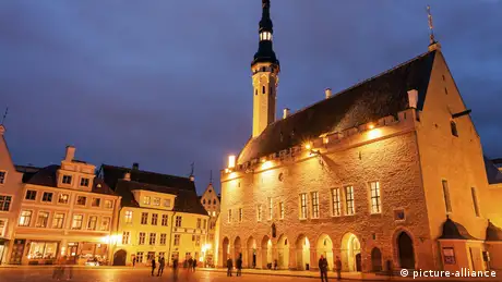 Tallinn's illuminated Town Hall seen from across square at dusk