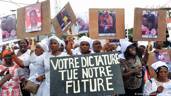 Guinean women hold placards reading Your dictatorship kills our future as they protest against killings of demonstrators and the third term of Guinean President Alpha Conde