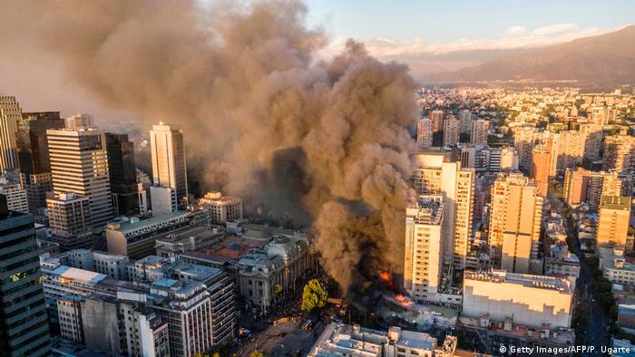 Un edificio en el centro de la ciudad de Santiago, consumido por las llamas durante las manifestaciones.