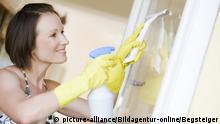 Junge Frau beim Fensterputzen