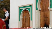 A police officer stands next to the entrance a mosque after an incident in Bayonne, southwestern France