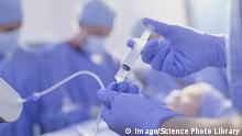 Anaesthesiologist injecting anaesthesia medicine Close up anaesthesiologist with syringe injecting anaesthesia medicine into IV drip in operating room PUBLICATIONxINxGERxSUIxHUNxONLY CAIAxIMAGE/SCIENCExPHOTOxLIBRARY F020/1648