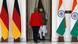 Merkel following Narendra Modi through a curtain flanked by German and Indian flags Merkel following Narendra Modi through a curtain flanked by German and Indian flags