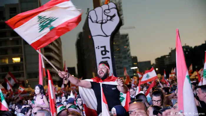 A demonstrator waves a national flag in Beirut's Martyrs' Square (REUTERS/Andres Martinez Casares)