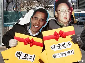 韩国抗议者拿着金正日与奥巴马的画像