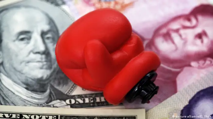 Boxhandschuh auf Dollarnoten und chinesischen Renminbi