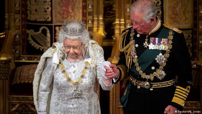 Prinz Charles hält die Hand seiner Mutter, beide prächtig gekleidet.