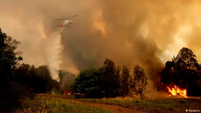 A fire bombing helicopter works to contain a bushfire 