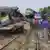 People gather near badly damaged coaches after two speeding trains collided in the Brahmanbaria district